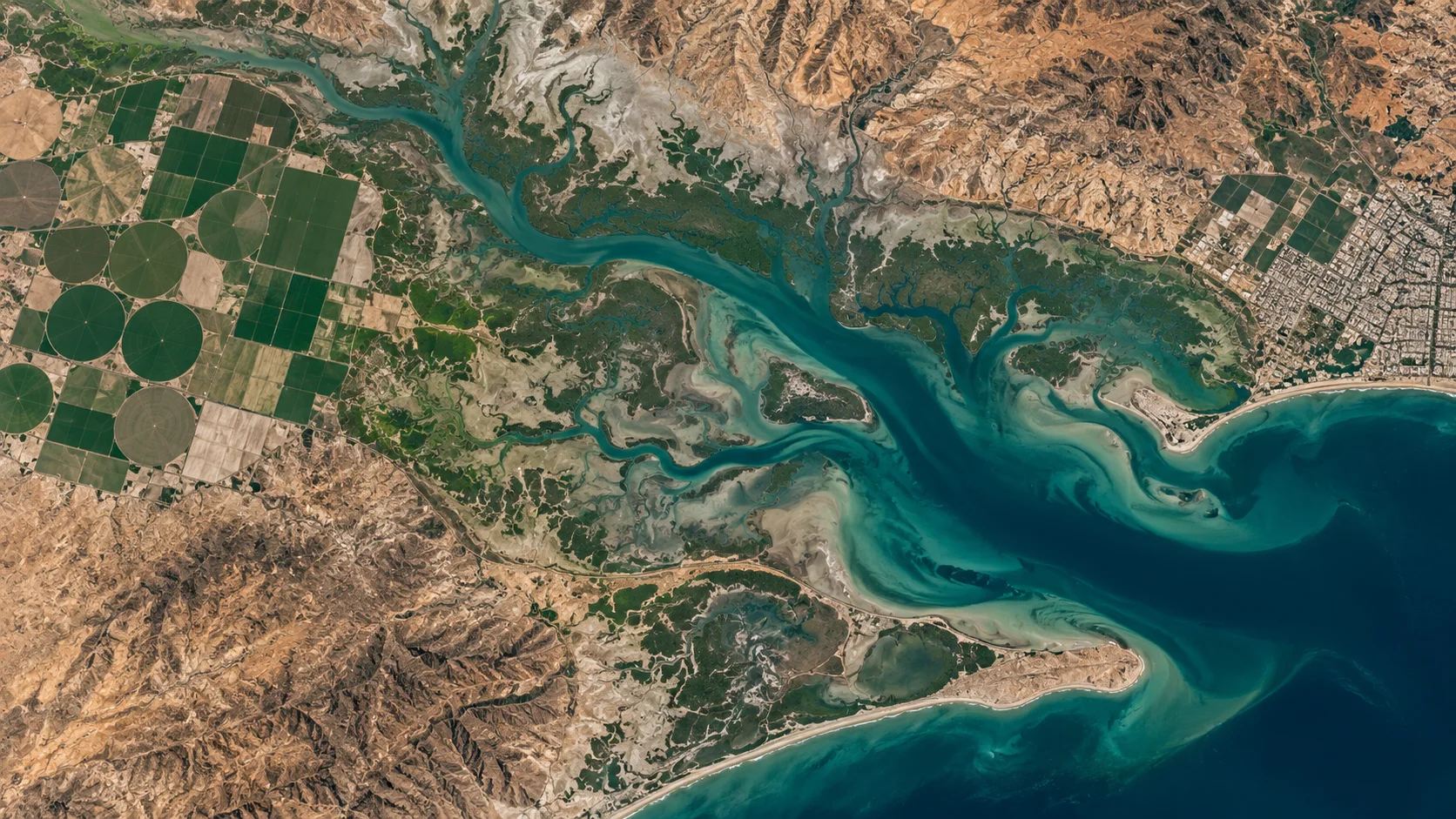 Illustrative aerial view of farmland, coastal water and settlements